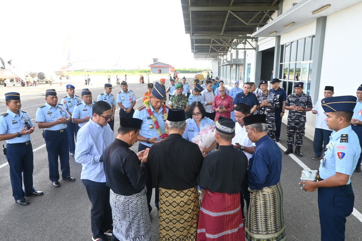 Prosesi Adat, Jajar Kehormatan, dan Forkopimda Sambut Danlanud RSA Baru di Natuna Komandan Lanud Raden Sadjad (Danlanud RSA) Natuna, Kolonel Pnb I Ketut Adiyasa Ambara, bersama Ketua PIA Ardhya Garini Cabang 17/D.I Lanud RSA, Ny. Dewi I Ketut Adiyasa, tiba di Natuna dengan sambutan hangat di Bandara Raden Sadjad, Natuna, Provinsi Kepulauan Riau, Sabtu(14/12/2024). Setibanya di bandara menggunakan pesawat, Komandan beserta rombongan disambut oleh jajaran pejabat, para Kepala Dinas (Kadis), Komandan Satuan, Pamen, serta pejabat daerah Kabupaten Natuna, termasuk Sekda Natuna, Ketua DPRD, dan Forkopimda lainnya. Penyambutan dimulai dengan pengalungan bunga, pemberian hand bouquet, serta prosesi tepung tawar oleh Ketua Adat Natuna. Selanjutnya, rombongan menuju gerbang Mako Lanud RSA, di sambut dengan tradisi Passing In Parade pasukan jajar kehormatan telah bersiap menyambut. Barisan pasukan terdiri dari perwira tradisi, Bintara dan Tamtama bersenjata, serta barisan seluruh personel. Komandan menerima penghormatan dengan berjalan melewati jajar kehormatan, diiringi lagu penyambutan menuju Lobby Mako Lanud RSA. Di lobby Mako Komandan menerima memorandum, penyerahan simbolik peralatan dinas, termasuk HT, kunci kantor, dan kunci mobil dinas dari Kadislog Lanud RSA. Setelah itu, dilakukan pemasangan papan nama jabatan Komandan Lanud RSA, prosesi diakhiri dengan foto bersama. Sementara acara penyambutan di Bandara RSA dihadiri sejumlah tokoh penting, seperti Kepala Staf Guspurla Koarmada I, Danlanal Ranai, Dandim 0318/Natuna diwakili Danramil 01/Ranai, Wakapolres Natuna, serta para tokoh agama dan adat. Tradisi Passing In Parade ini menjadi simbol penghormatan dan kebanggaan atas kedatangan Komandan baru, diharapkan dapat membawa Lanud RSA ke arah yang lebih baik dan berkontribusi bagi keamanan serta kesejahteraan wilayah Natuna. Tradisi penyambutan ini menegaskan semangat kekompakan dan kebersamaan keluarga besar Lanud RSA dan Forkopimda Natuna dalam menyambut pemimpin baru.